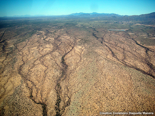 Aerial view of rural, semi-arid Arizona, USA showing small shrubs and trees outlining basin waterways and features